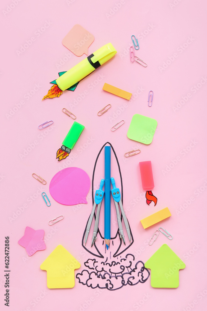 Creative composition with drawn rocket and different stationery on pink background