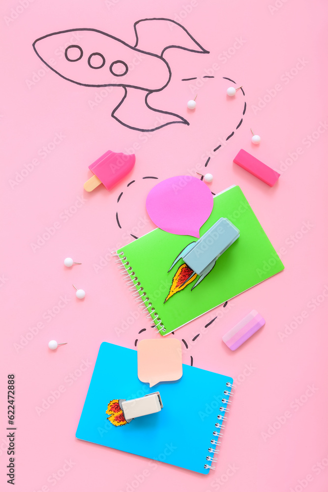 Creative composition with drawn rocket and different stationery on pink background