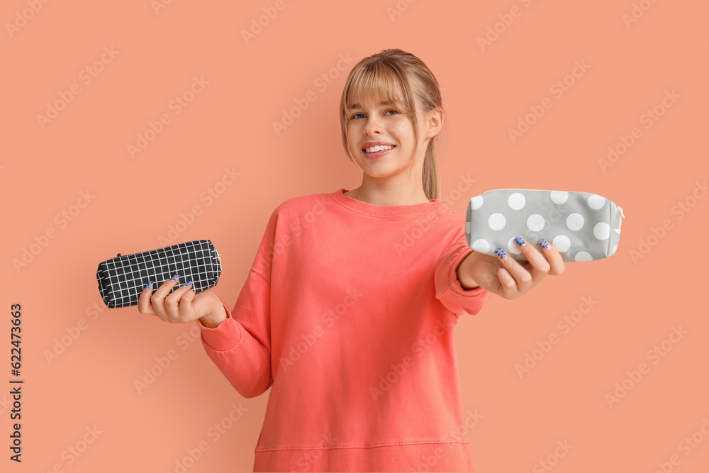 Female student with pencil cases on color background