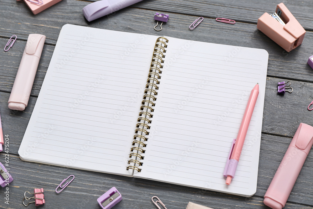 Blank notebook with different stationery on grey wooden background