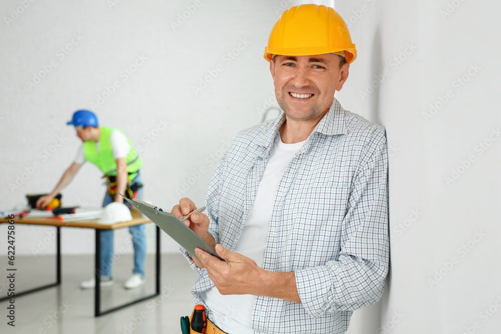 Mature builder with clipboard in room