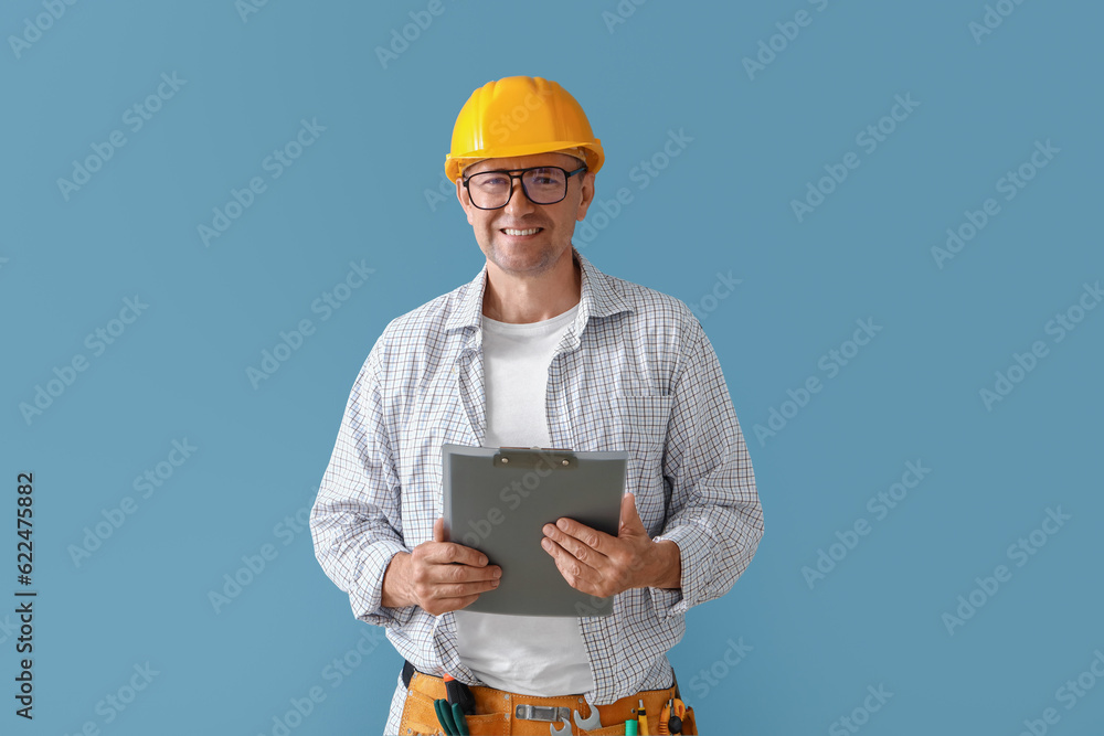 Mature builder with clipboard on blue background