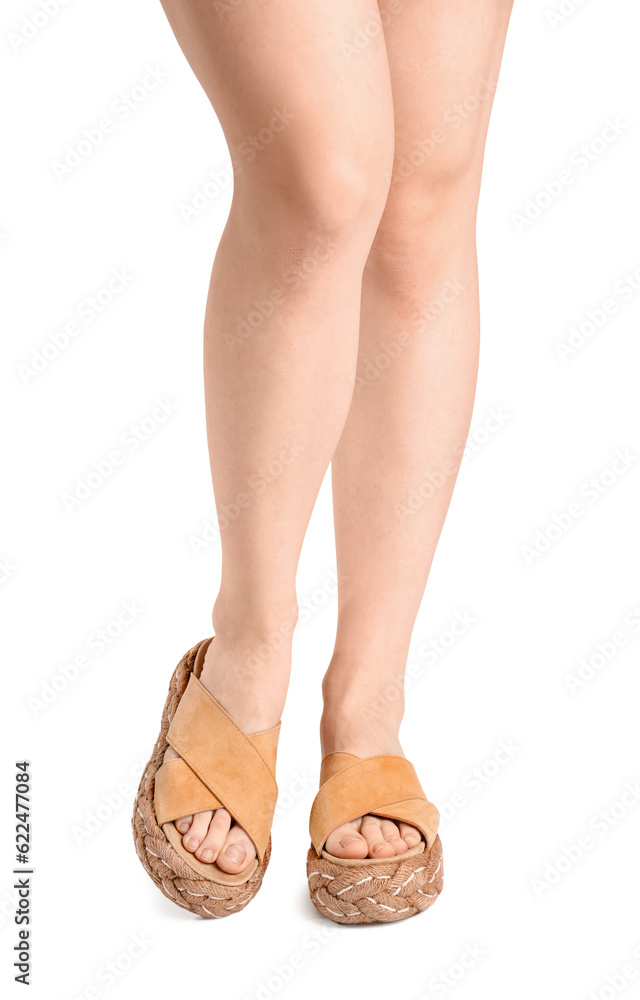 Female legs in flip-flops on white background