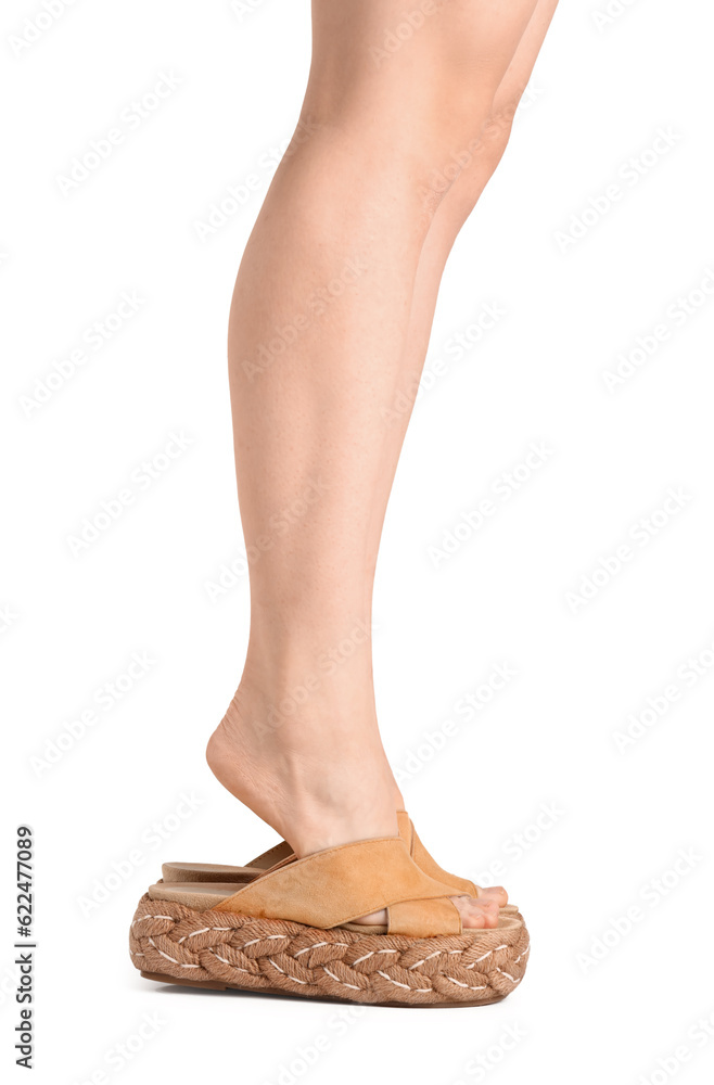 Female legs in flip-flops on white background