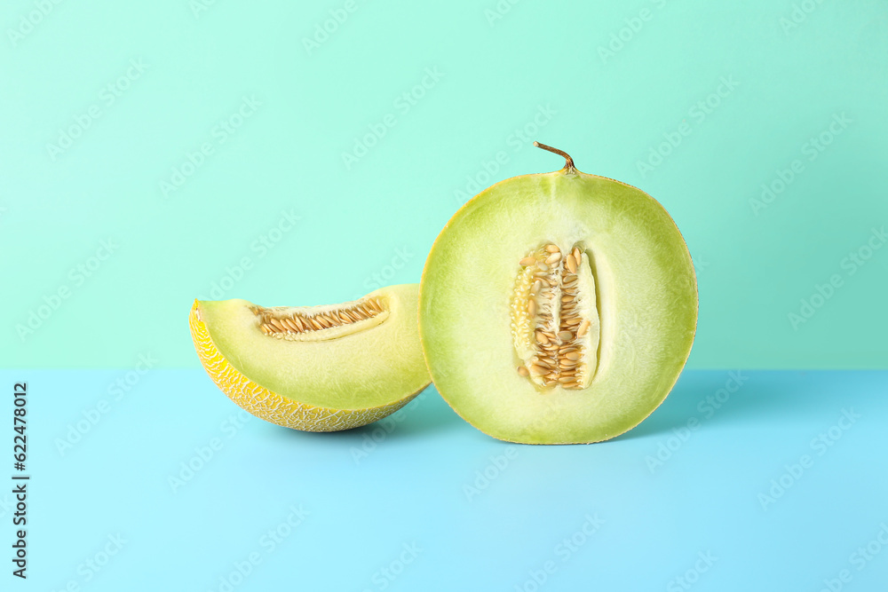 Half of sweet melon with piece on blue background