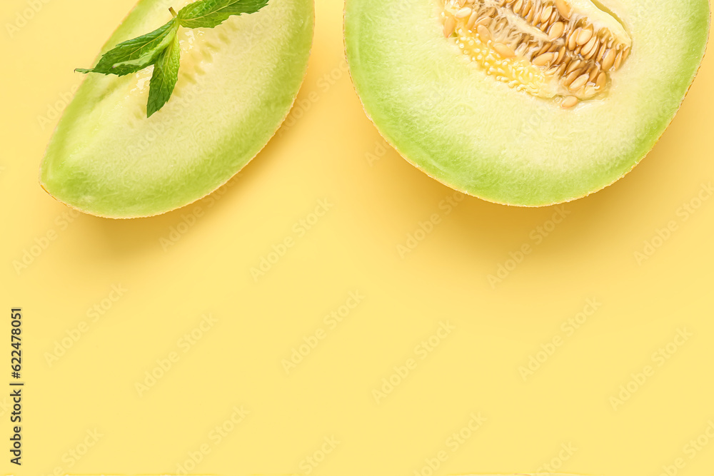 Half of sweet melon with piece and mint on yellow background