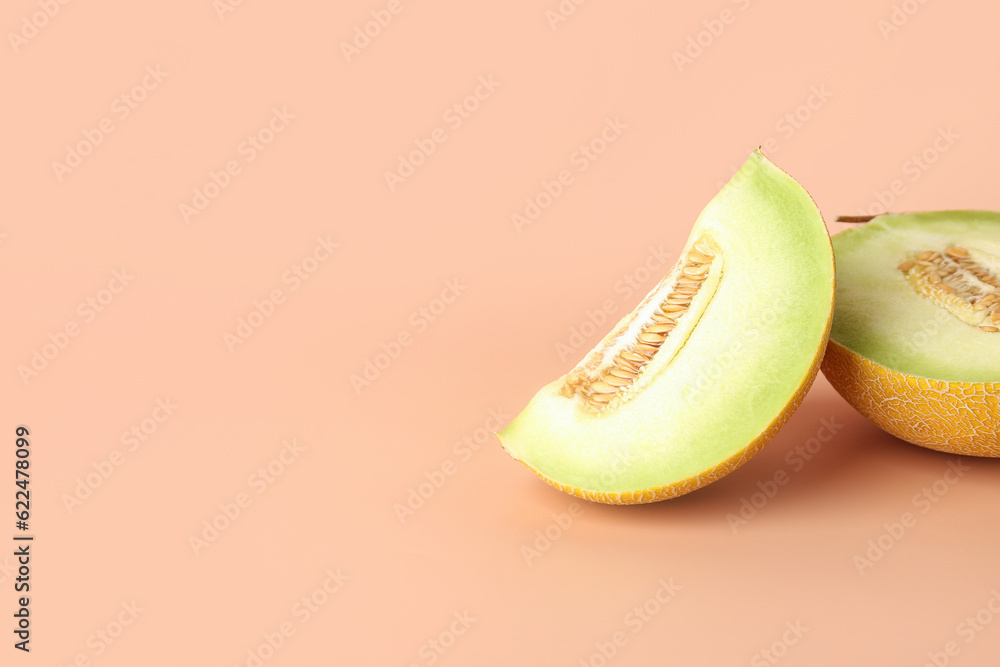 Half of sweet melon with piece on orange background