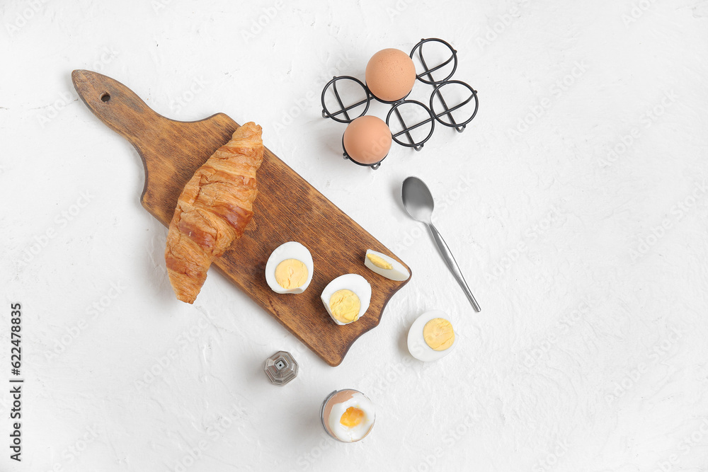 Holders with boiled chicken eggs on white background