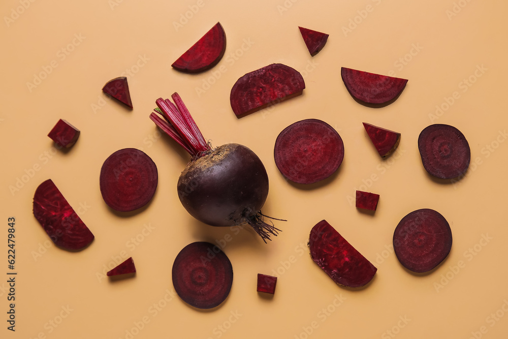 Whole and cut beet on beige background