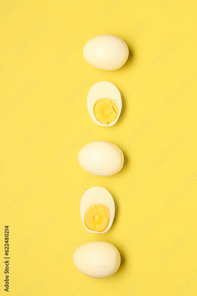 Tasty boiled eggs with halves on yellow background