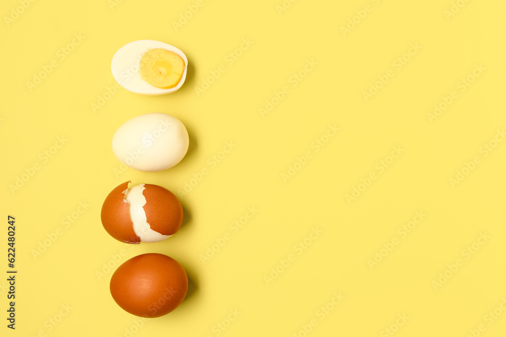 Tasty boiled eggs with half on yellow background