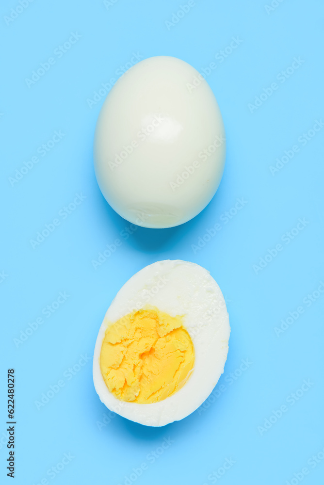 Tasty boiled egg with half on blue background