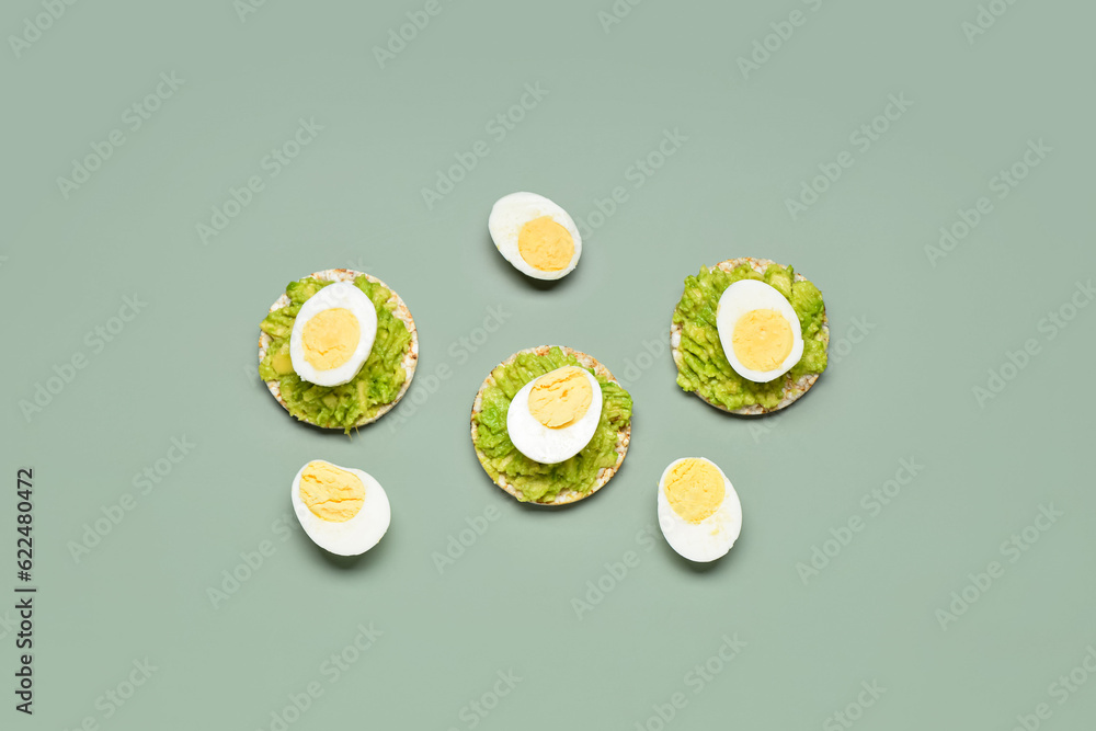 Rice crackers with boiled eggs and avocado on grey background