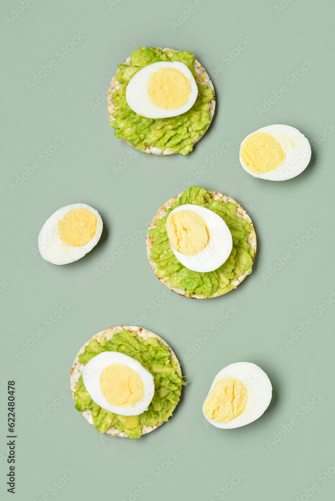 Rice crackers with boiled eggs and avocado on grey background