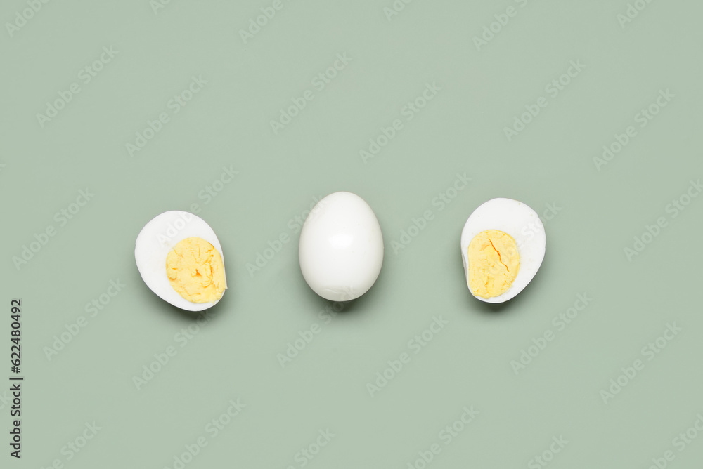 Tasty boiled eggs with half on grey background