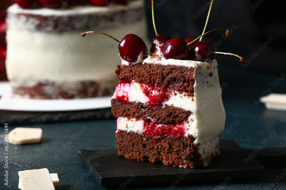 Board with piece of tasty cherry cake on table