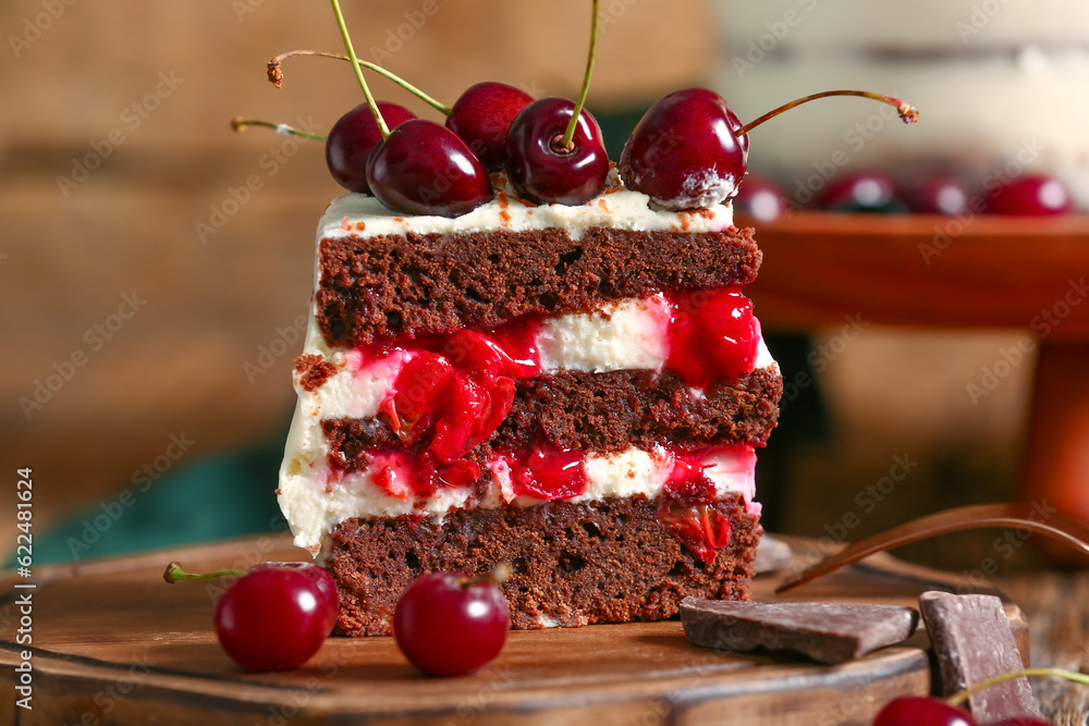 Board with piece of tasty cherry cake on wooden background