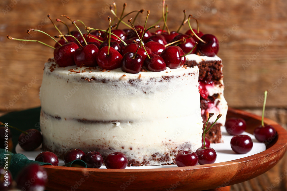 Stand with tasty cherry cake on wooden background