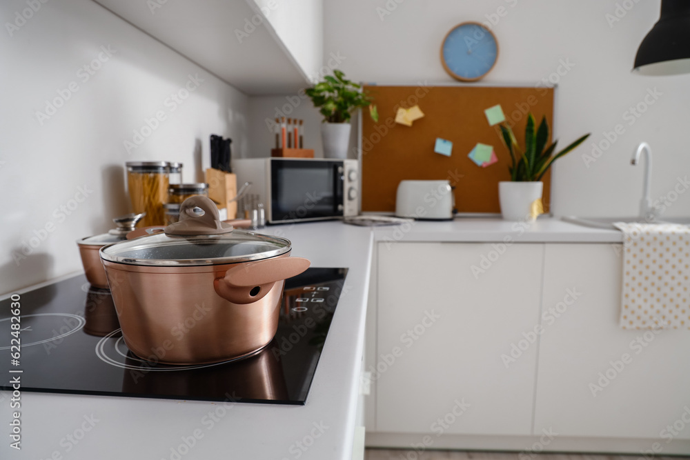 Modern kitchen with cooking pot on induction stove, closeup