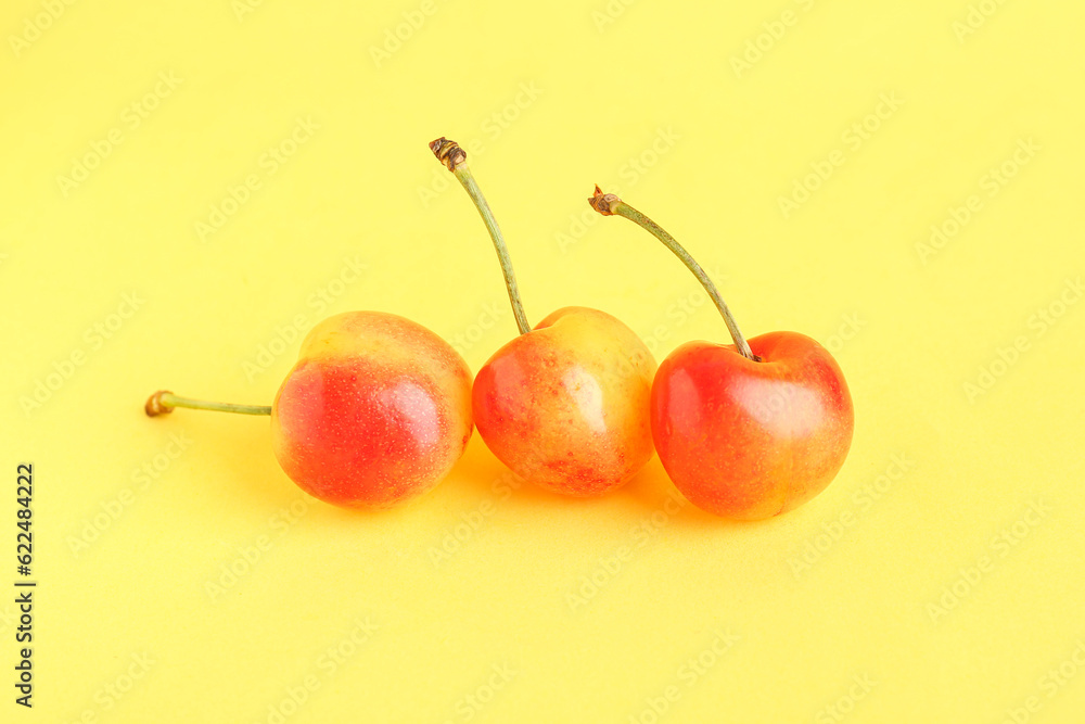 Sweet yellow cherries on color background