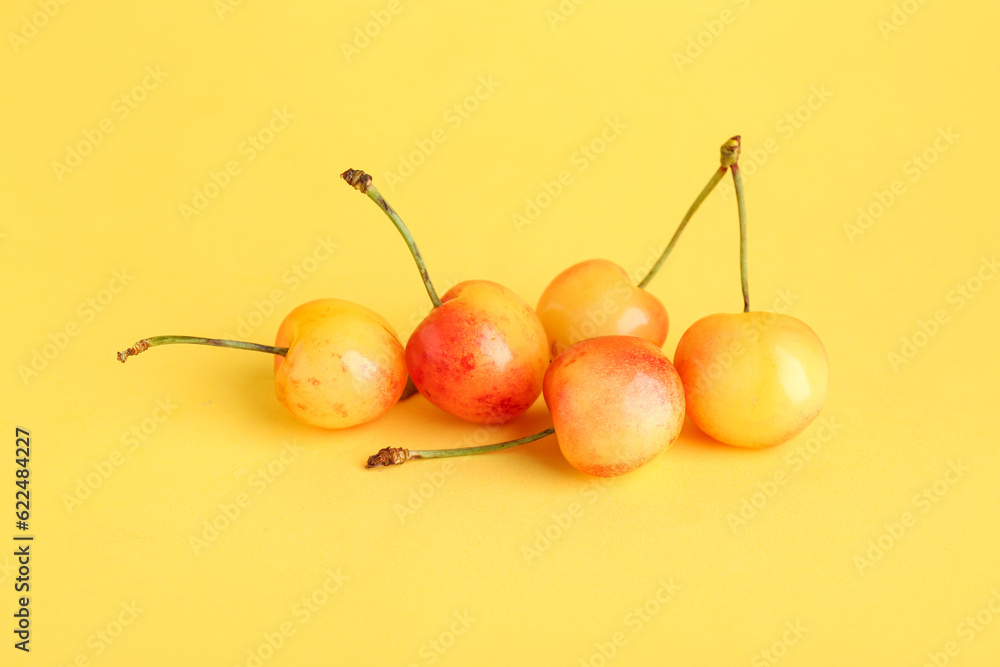 Sweet yellow cherries on color background