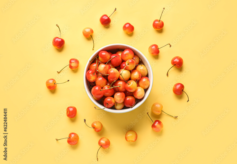 Bowl with sweet yellow cherries on color background