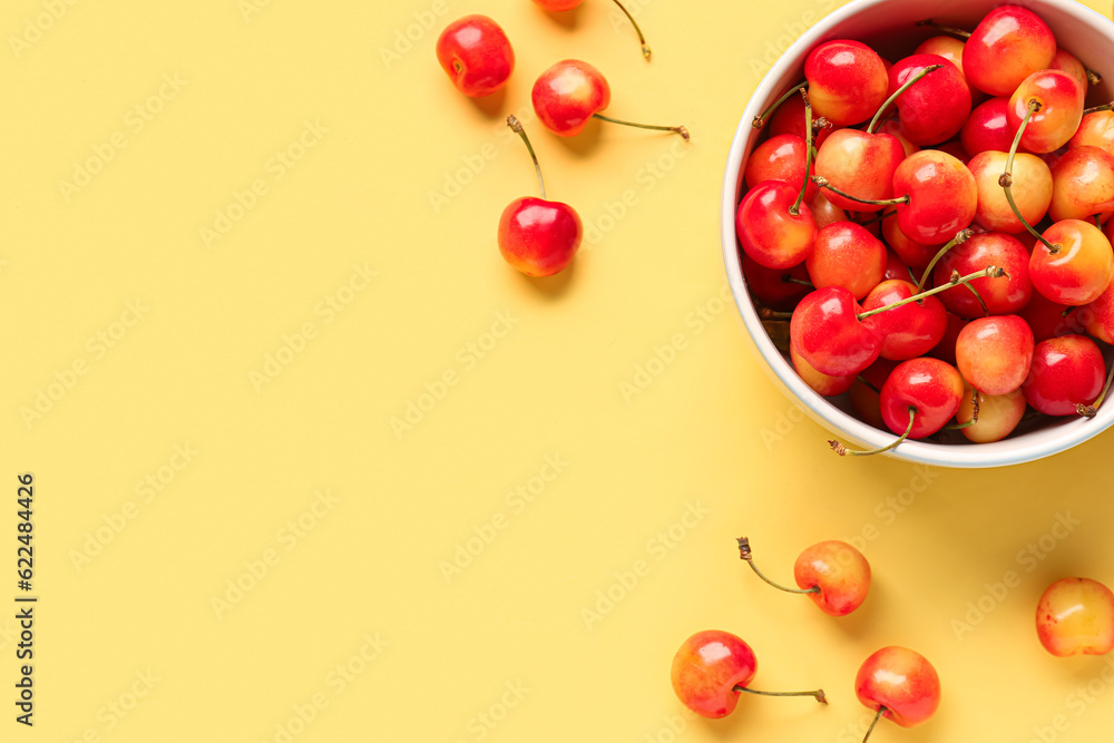 Bowl with sweet yellow cherries on color background