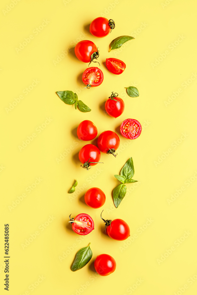 Fresh cherry tomatoes and basil on yellow background