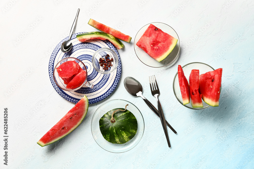 Glass bowl and cup with pieces of fresh watermelon on white background