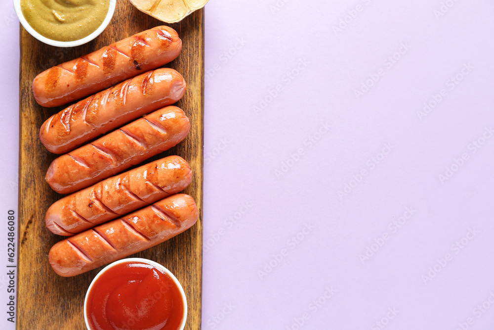 Wooden board with tasty grilled sausages and sauces on lilac background