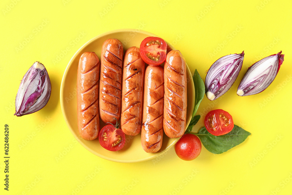 Plate with tasty grilled sausages on yellow background