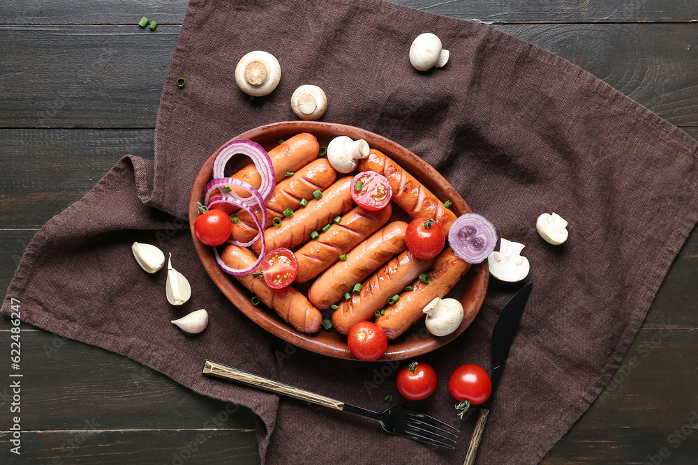 Plate with tasty grilled sausages on brown wooden background