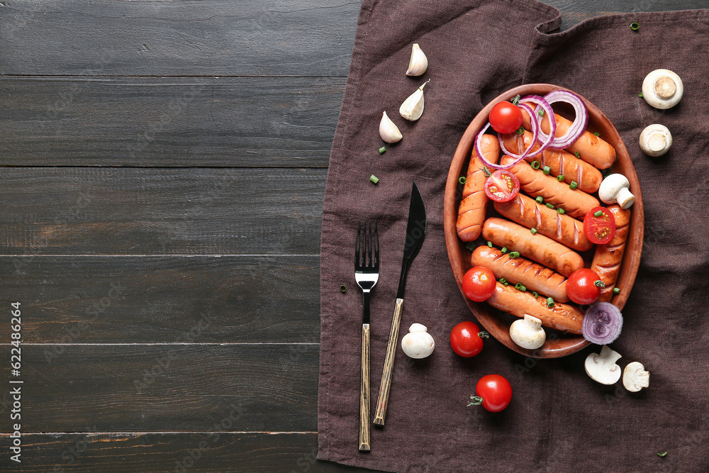 Plate with tasty grilled sausages on brown wooden background