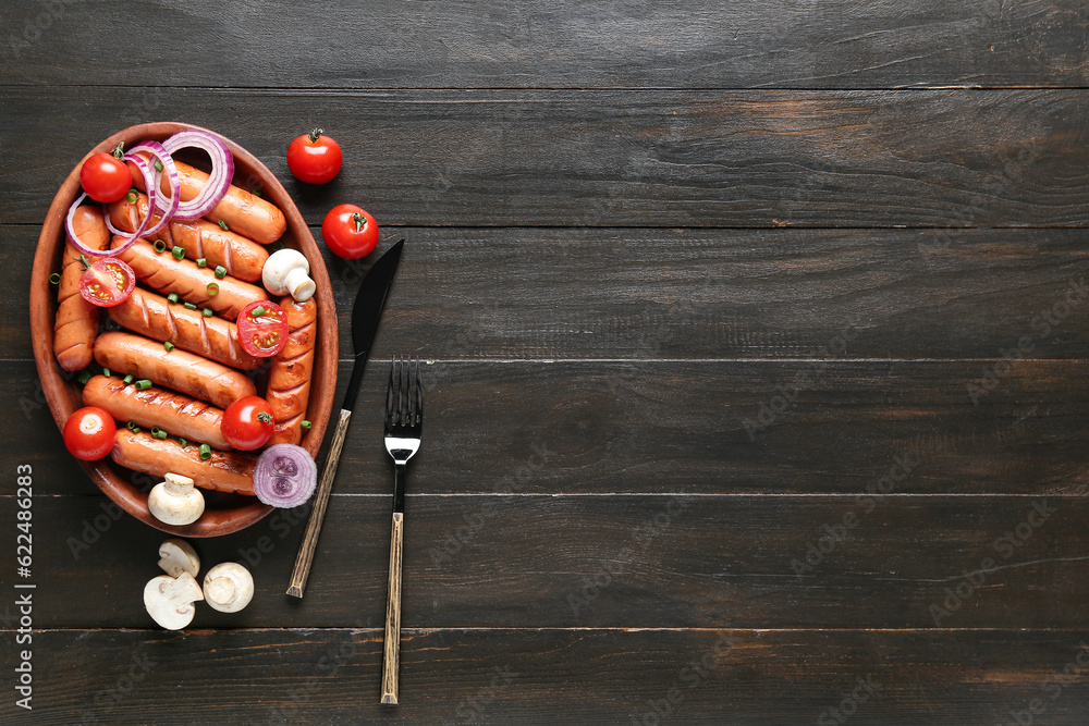 Plate with tasty grilled sausages on brown wooden background