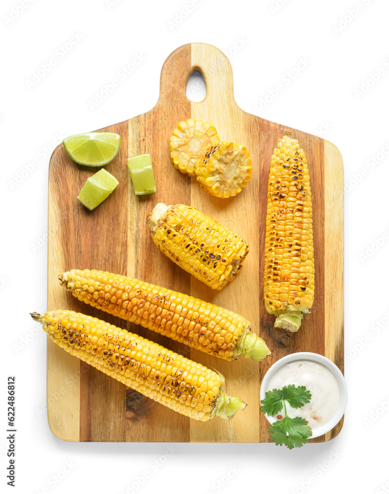 Wooden board with tasty grilled corn cobs and sauce on white background