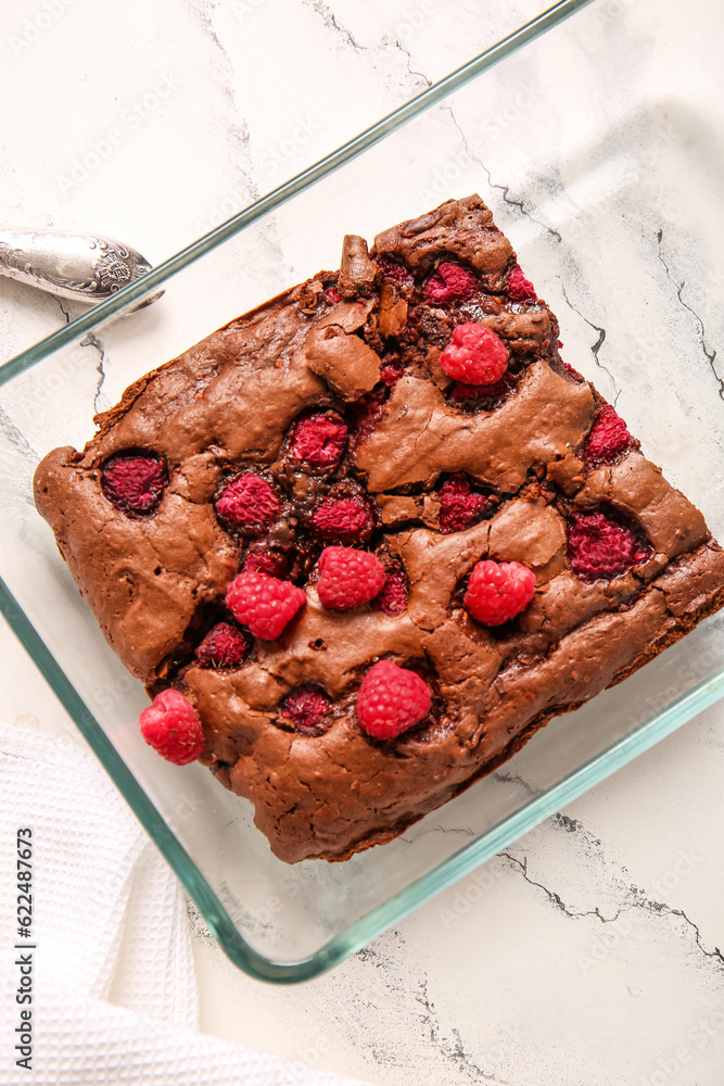 Baking dish with raspberry chocolate brownie on white background