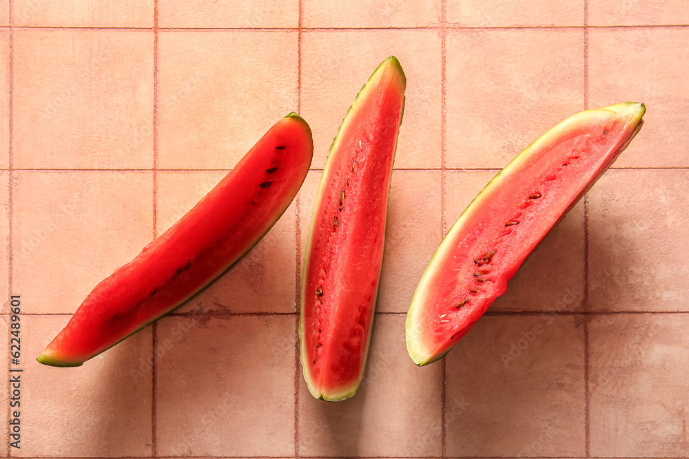 Pieces of fresh watermelon on pink tile table