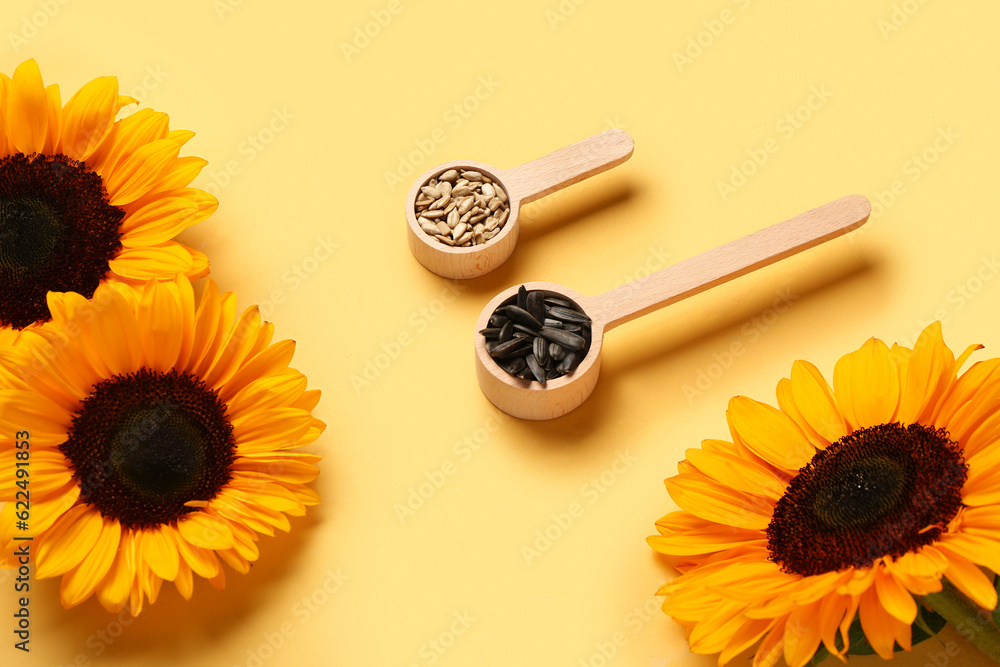 Sunflowers and spoons with seeds on yellow background