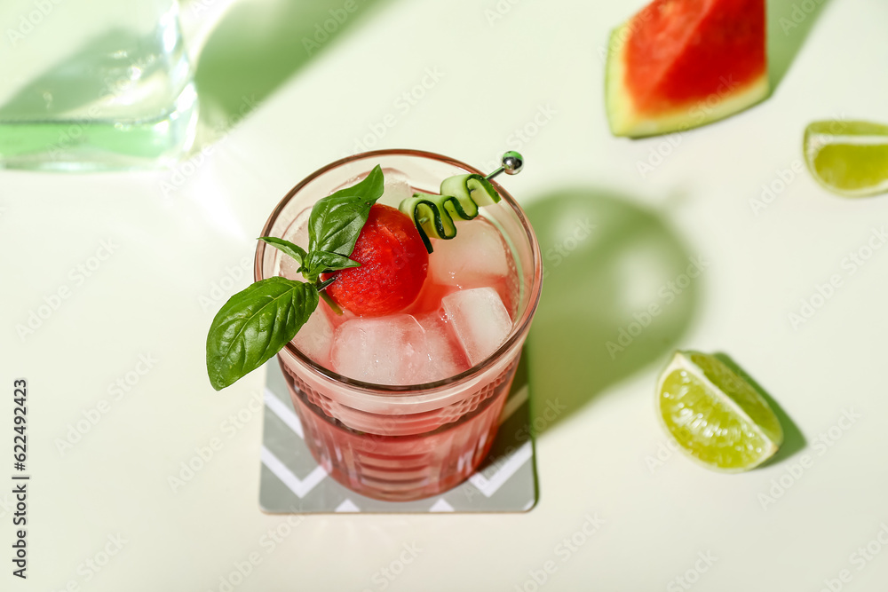 Glass of tasty watermelon cocktail with mint and lime on white background