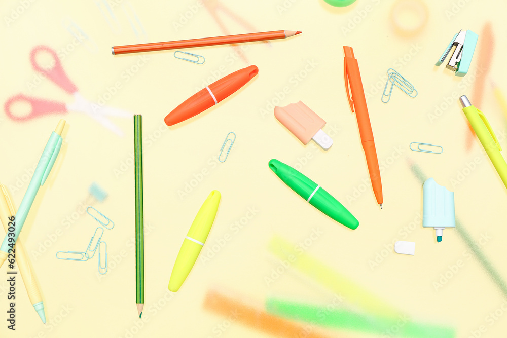 Different stationery on pale yellow background