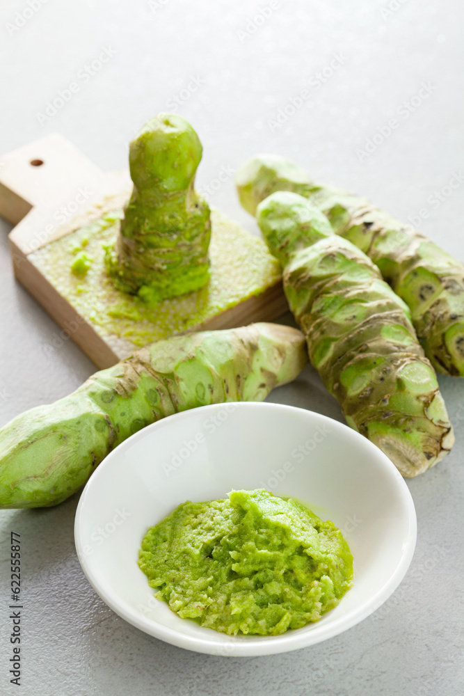 grated fresh wasabi and wasabi roots on a kitchen slab.