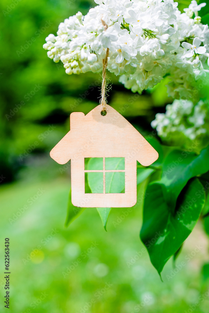 The symbol of the house among the branches of the white lilac