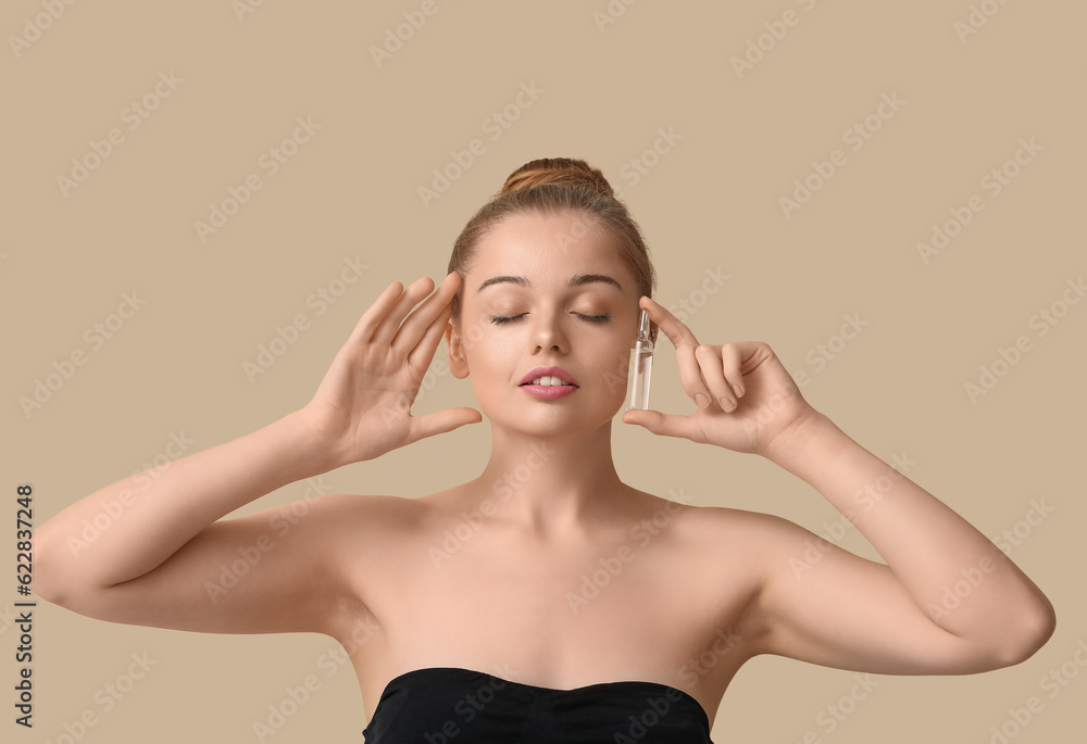 Beautiful young woman with ampule on beige background. Skin care concept