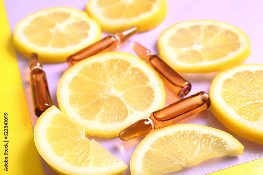 Ampoules with vitamin C and lemon slices on colorful background, closeup