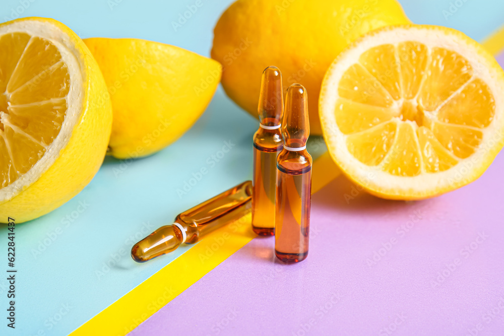 Ampoules with vitamin C and lemon on colorful background, closeup