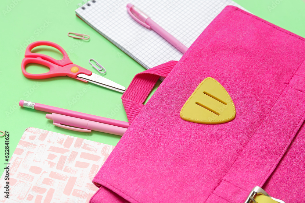 School backpack, notebooks and stationery on color background, closeup