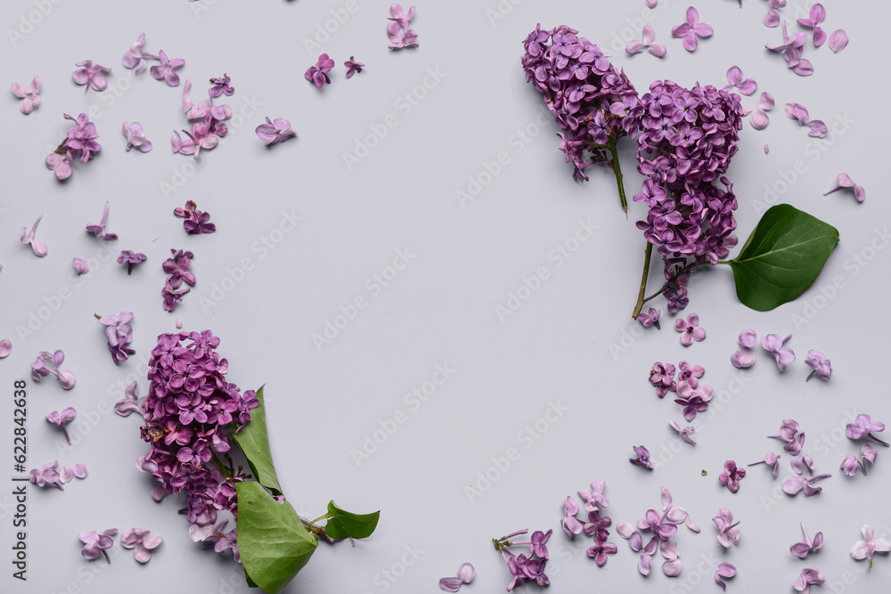 Frame made of beautiful bright lilac flowers on light background