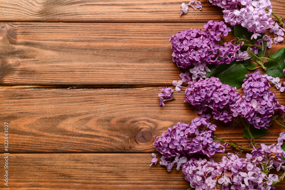 Beautiful bright lilac flowers on wooden background