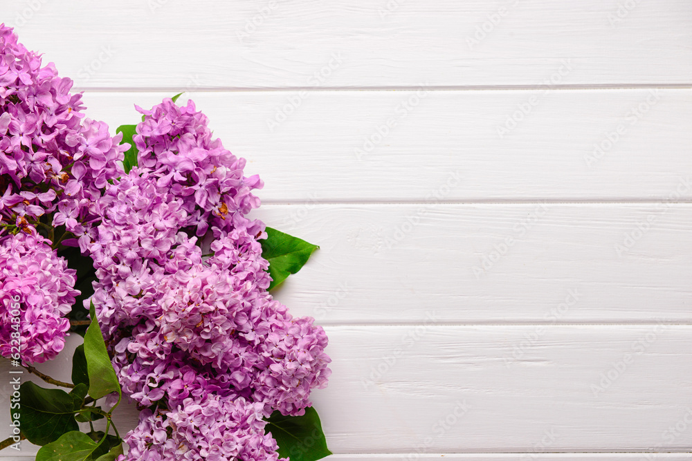 Beautiful lilac flowers on light wooden background