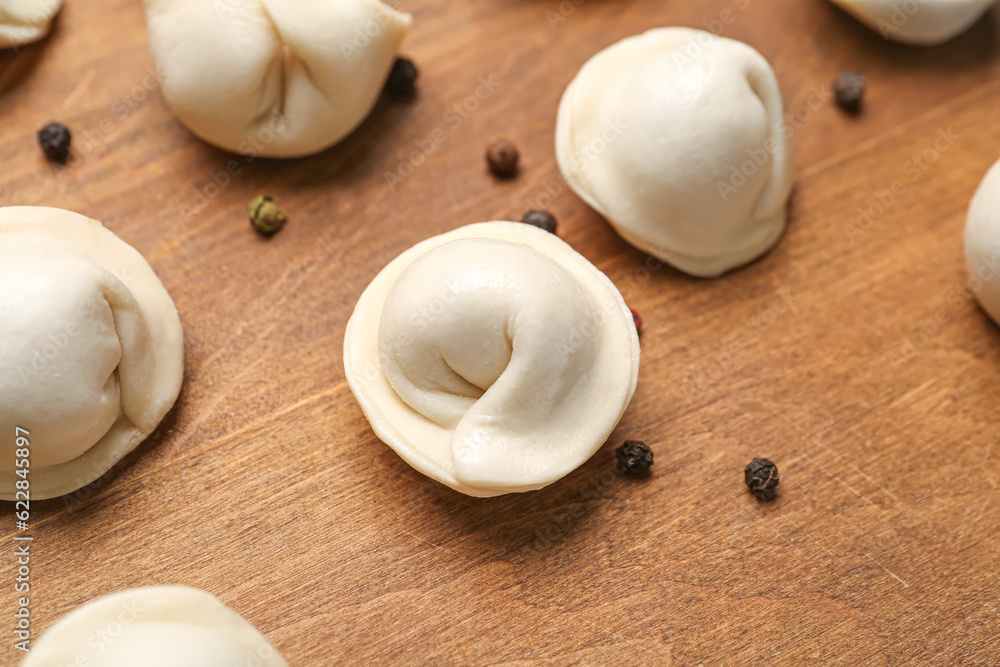 Uncooked dumplings on wooden background